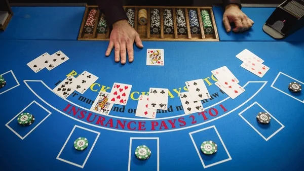 Mesa de blackjack con cartas y fichas en casino profesional